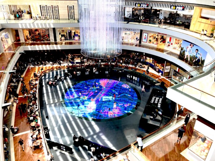 シンガポール・マリーナベイサンズのショッピングモールにある teamLab「Digital Light Canvas」。円形LEDフロアの映像演出と来場客の様子
