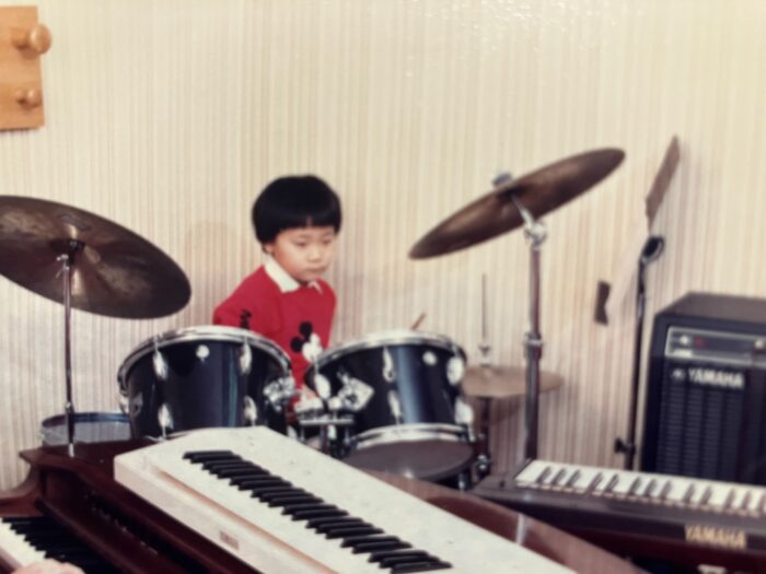 青木賢一郎さんの幼少期|ドラムセットで練習する様子
